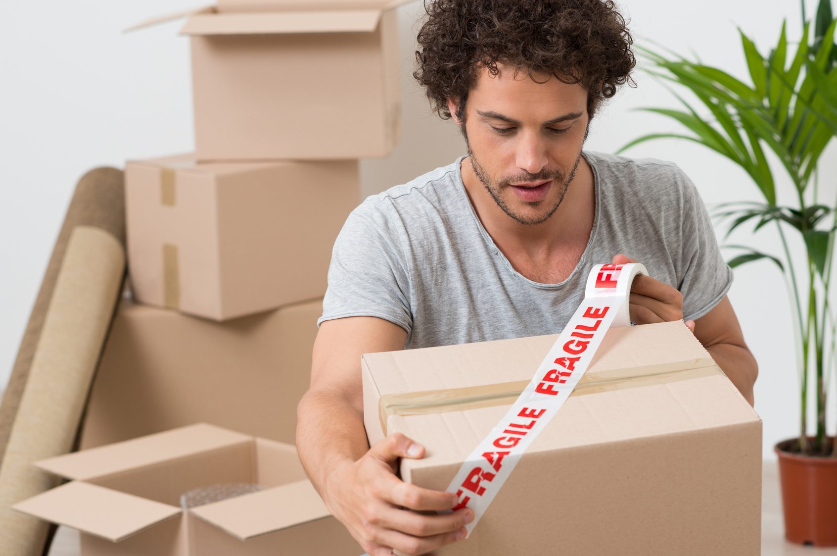 Young Man Packing Cardboard Box